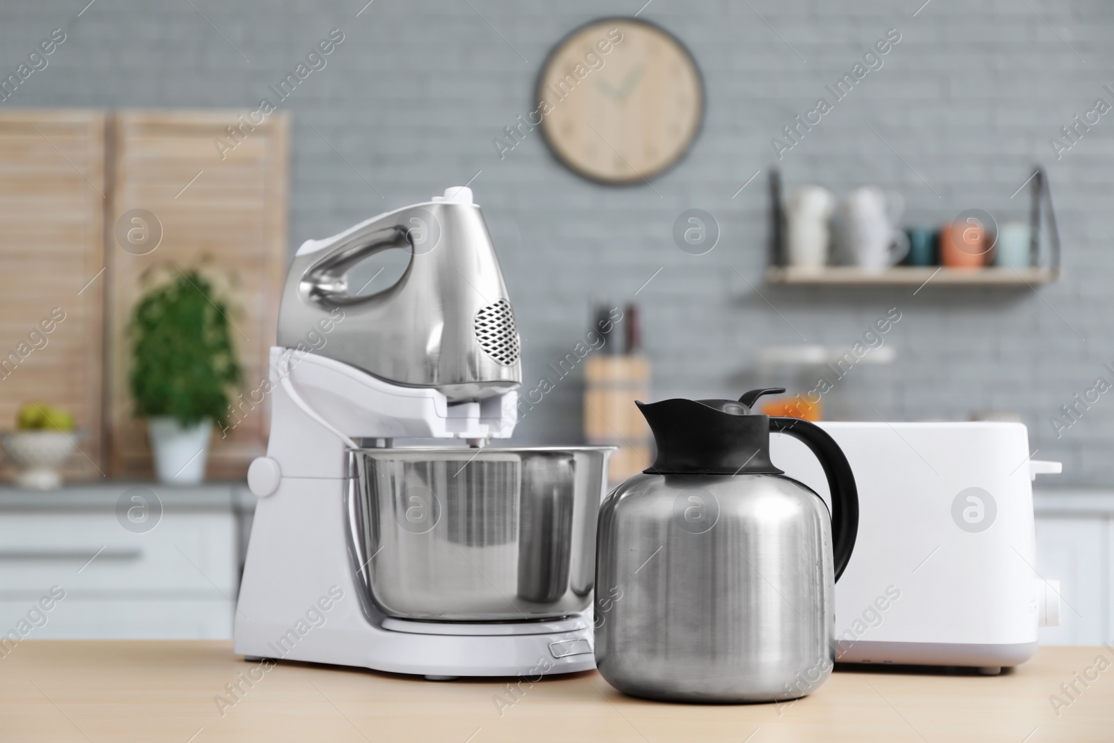 Photo of Different modern kitchen appliances and blurred view of kitchen interior on background