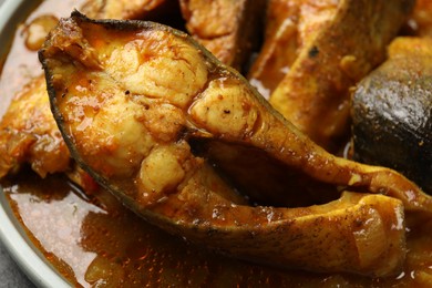 Photo of Tasty fish curry on plate, closeup. Indian cuisine