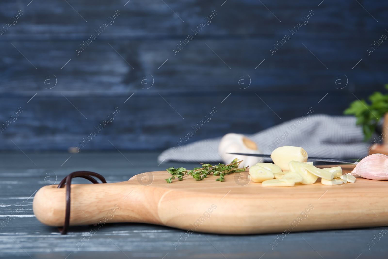 Photo of Wooden board with fresh garlic on table