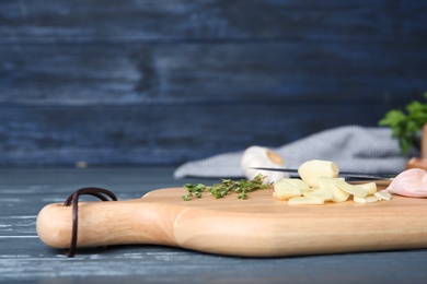 Wooden board with fresh garlic on table