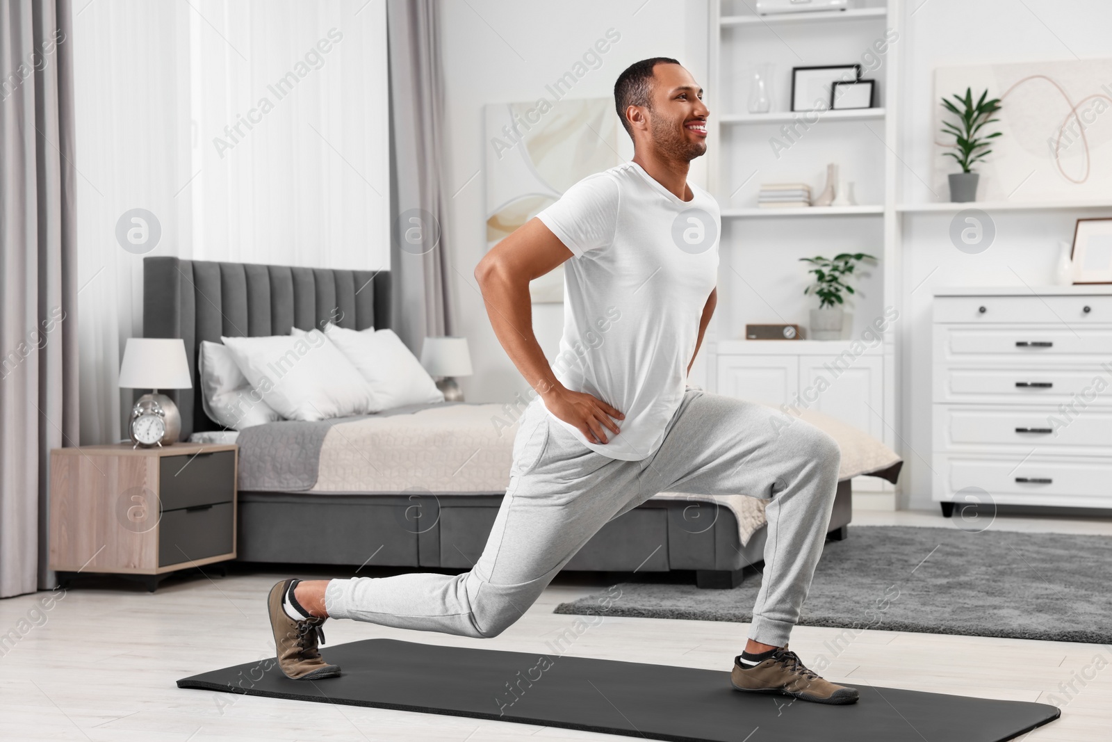 Photo of Man doing morning exercise on fitness mat at home