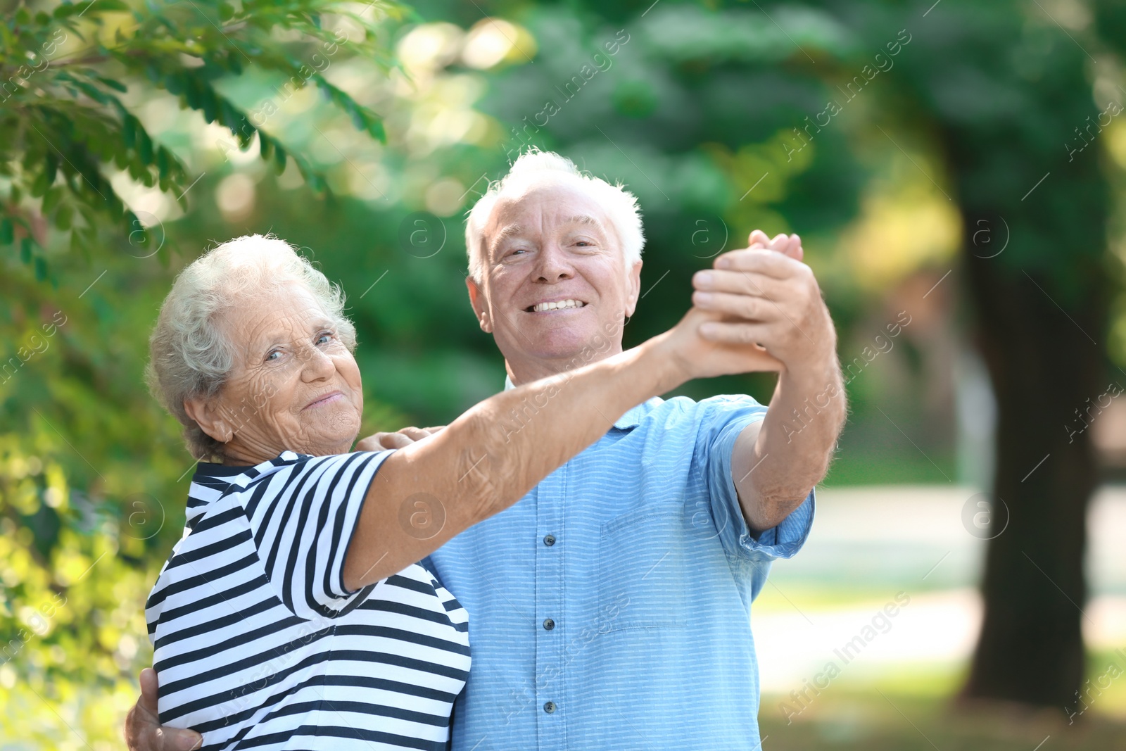 Photo of Cute elderly couple dancing outdoors. Time together