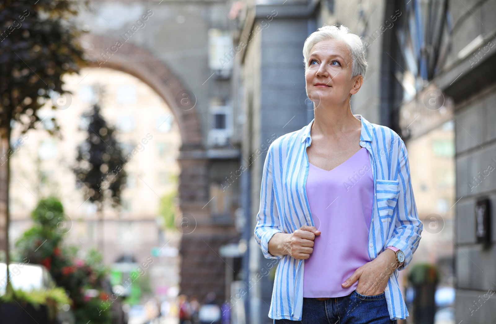 Photo of Happy mature woman on city street, space for text. Smart aging