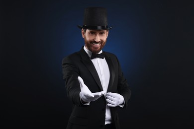 Happy magician in top hat on dark blue background