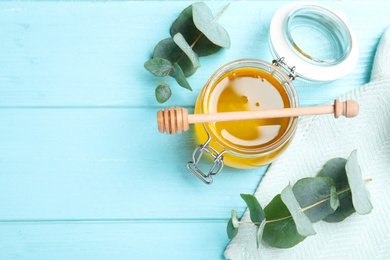 Flat lay composition with fresh honey on light blue wooden table. Space for text