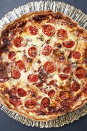 Delicious homemade quiche with prosciutto and tomatoes on table, top view