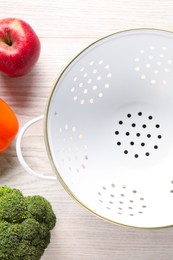 Photo of Empty colander, fresh fruit and vegetables on white wooden table, flat lay