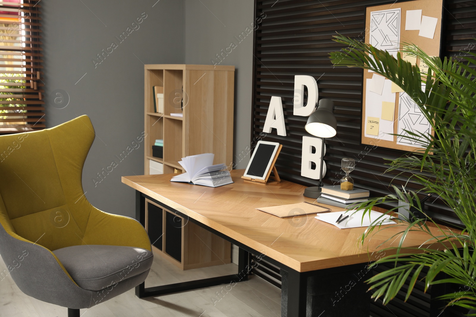 Photo of Comfortable workplace with wooden table and armchair