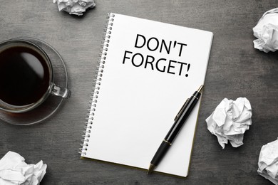 Image of Reminder DON'T FORGET written in notebook on grey table, flat lay 