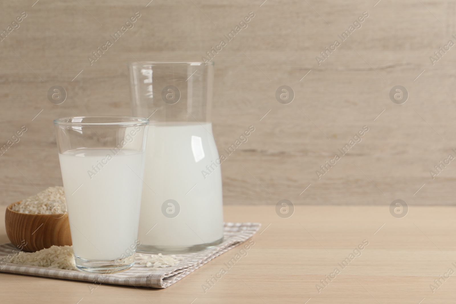 Photo of Natural rice water and grains on wooden table. Space for text