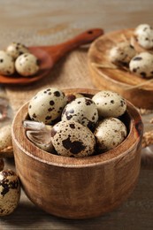 Photo of Bowl with quail eggs on wooden table