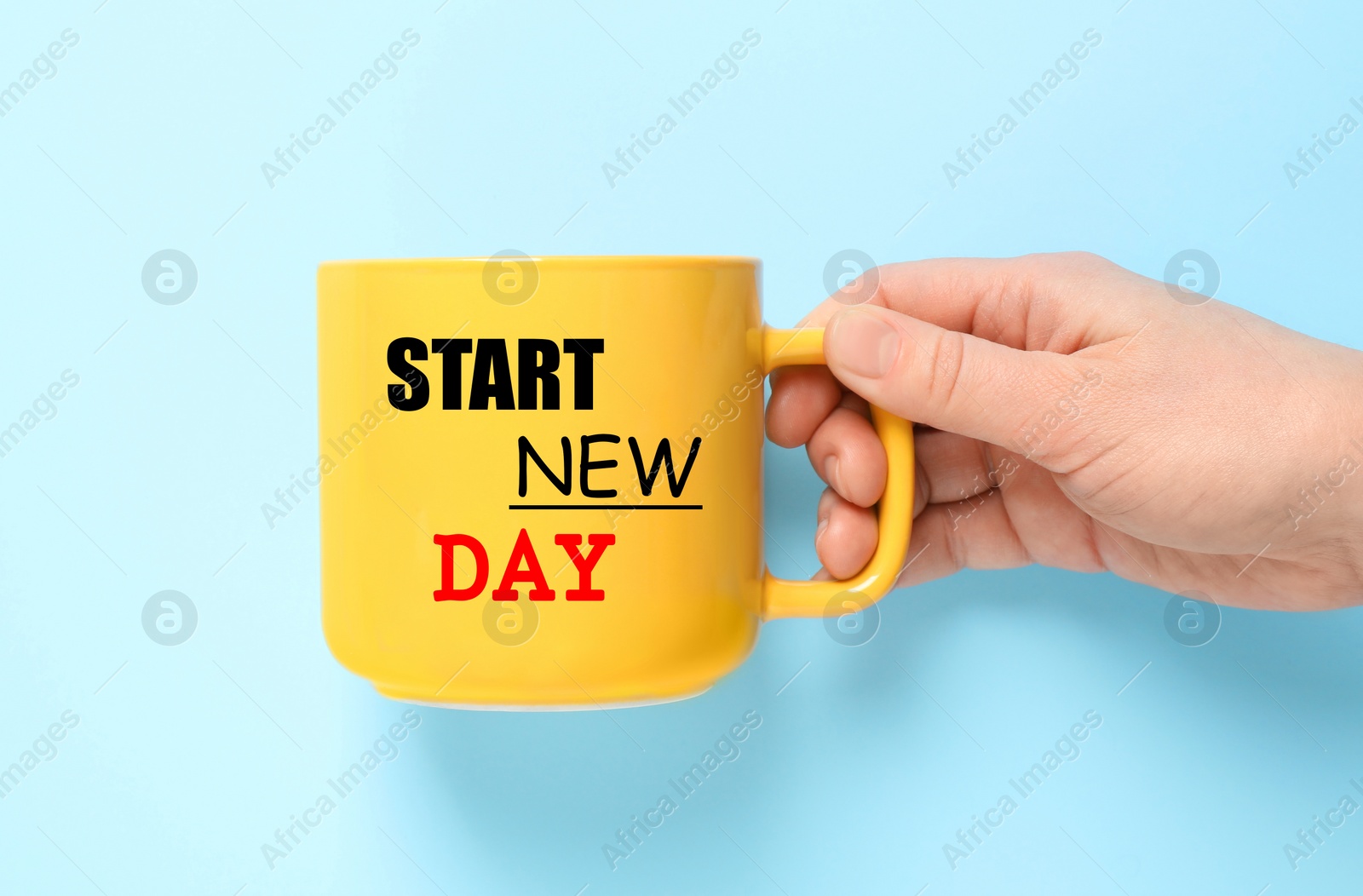 Image of Woman holding cup with words START NEW DAY on light blue background, closeup
