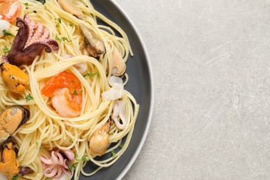 Delicious pasta with sea food on grey table, top view. Space for text