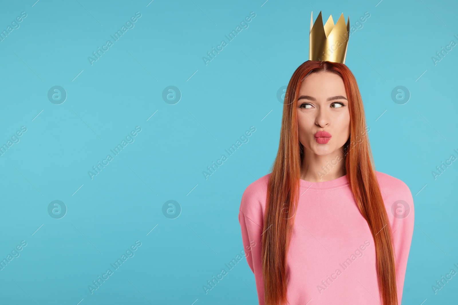 Photo of Beautiful young woman with princess crown on light blue background, space for text