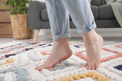 Woman standing on soft carpet at home, closeup