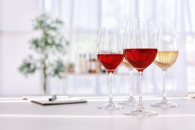 Photo of Glasses with delicious wine on table indoors