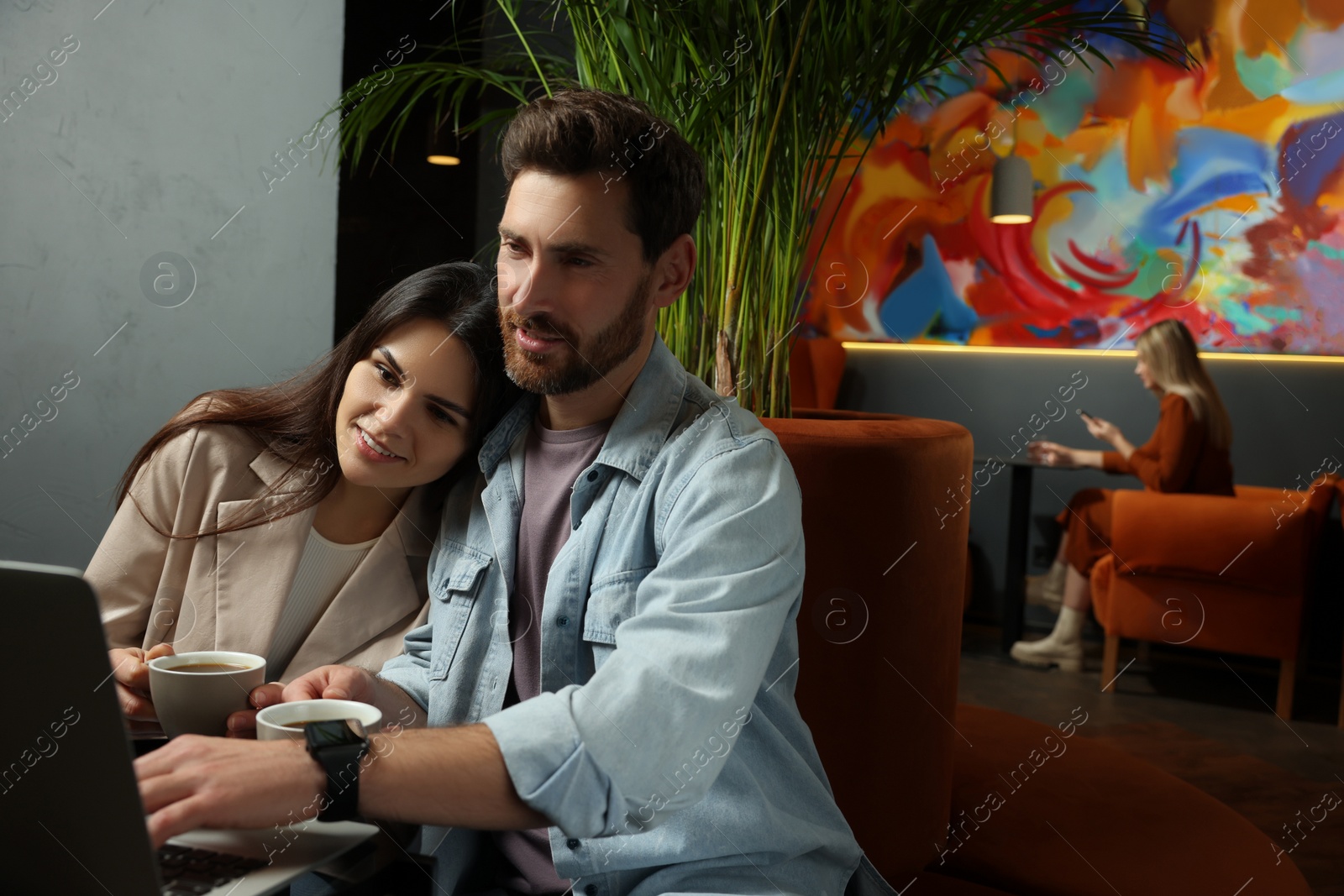 Photo of Couple with coffee and laptop spending time together in cafe, space for text