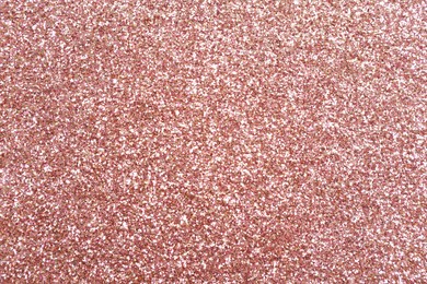 Photo of Beautiful rose gold shiny glitter as background, top view
