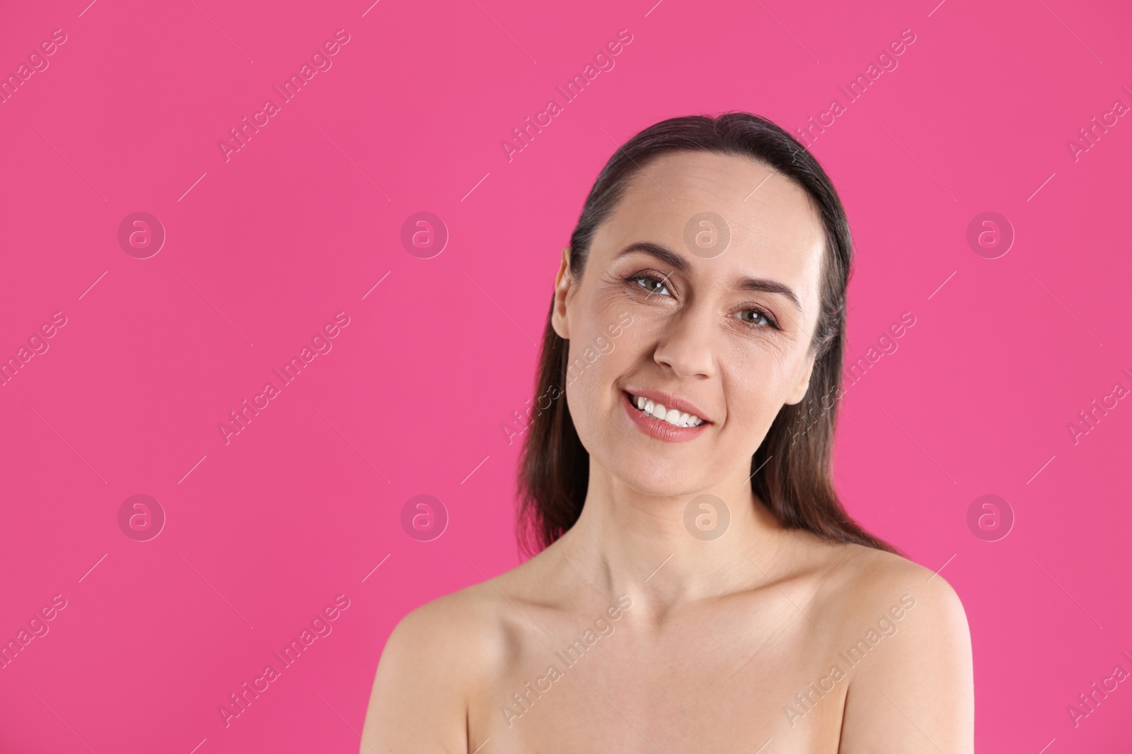 Photo of Portrait of beautiful mature woman on pink background. Space for text