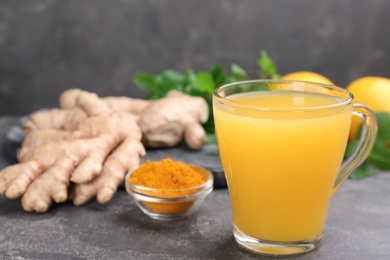 Photo of Immunity boosting drink and ingredients on grey table, closeup