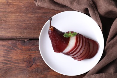 Tasty red wine poached pear on wooden table, top view. Space for text