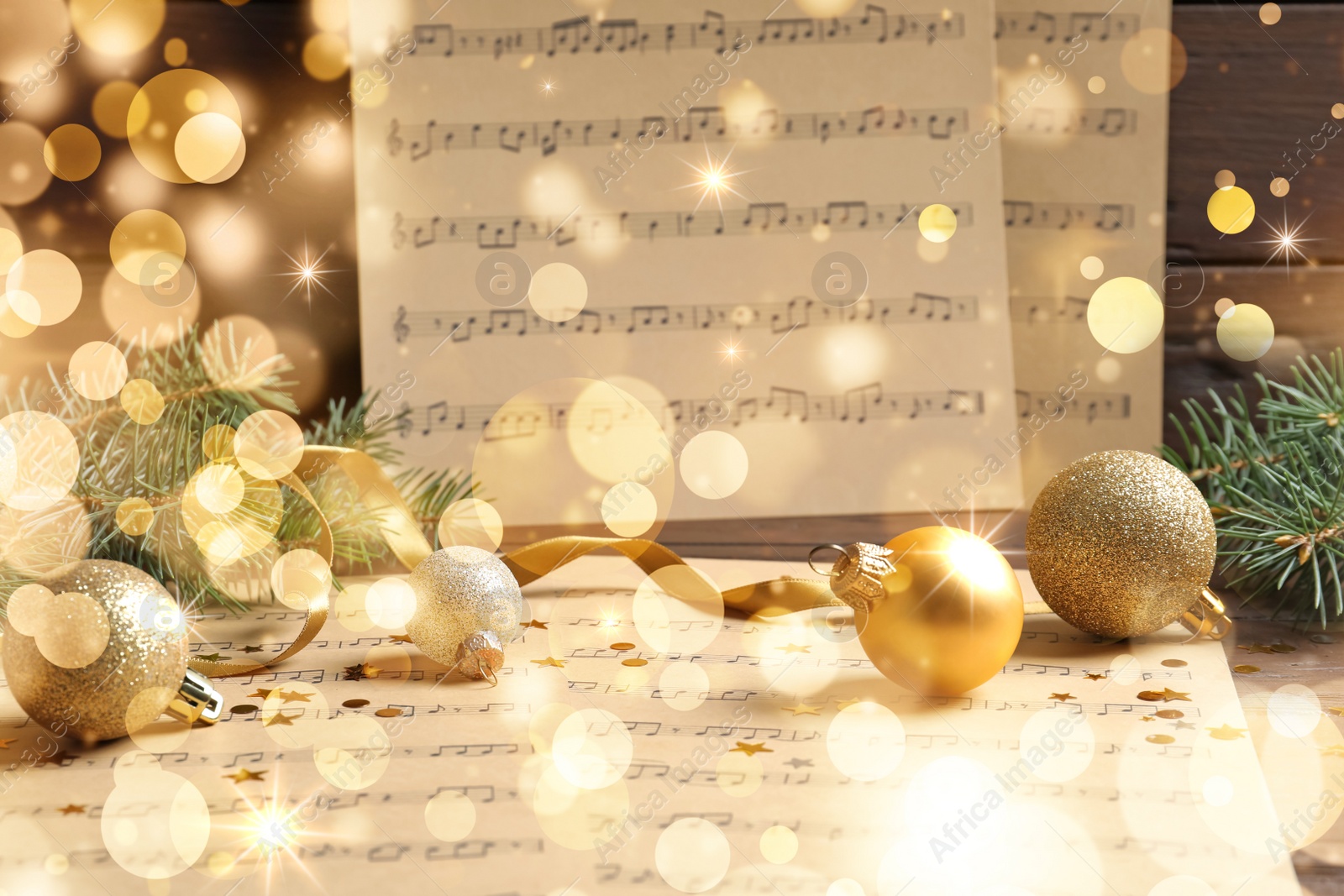 Image of Composition with Christmas decorations and music sheets on table. Bokeh effect