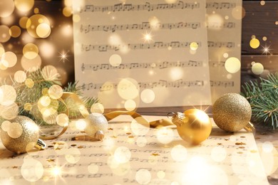 Image of Composition with Christmas decorations and music sheets on table. Bokeh effect