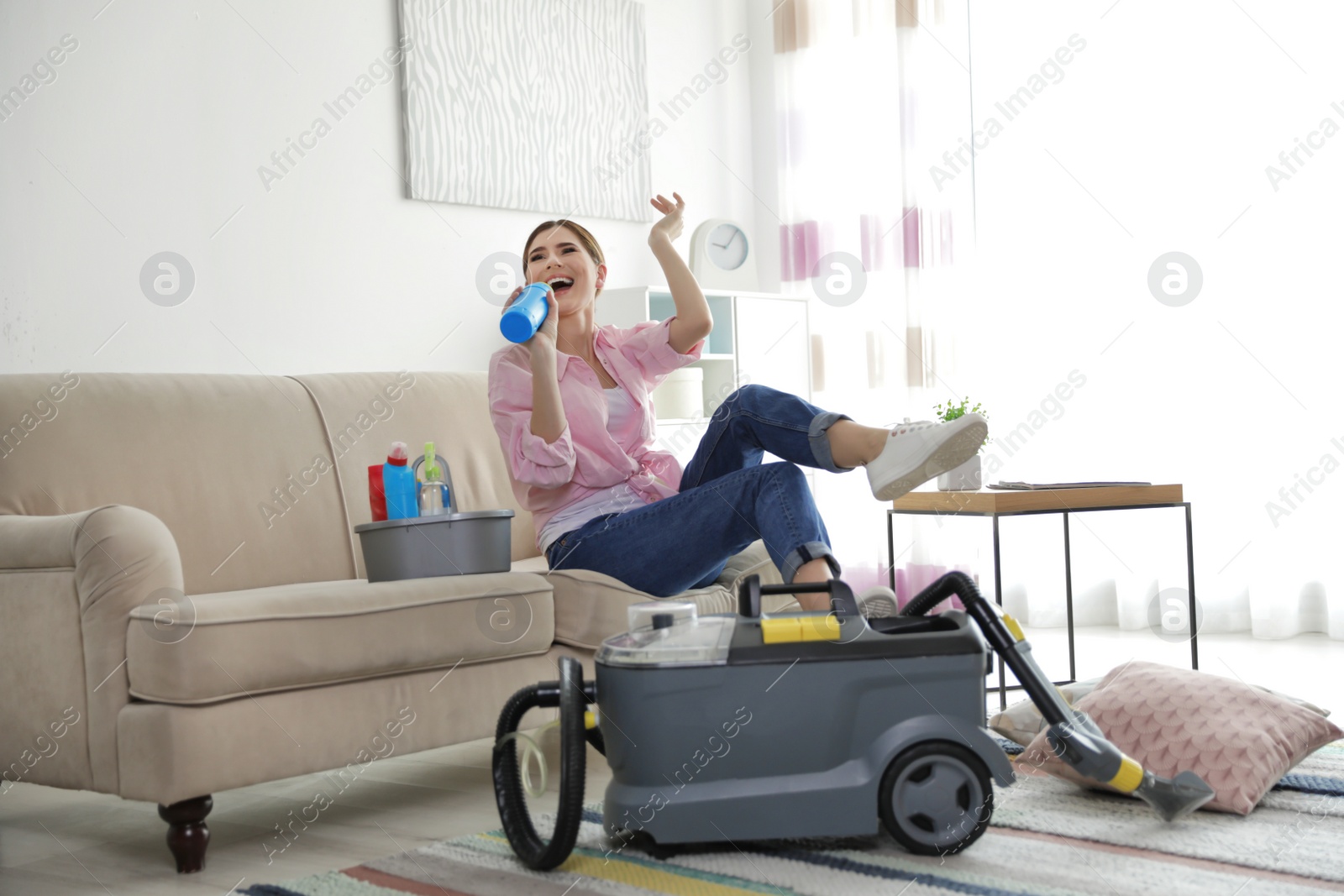 Photo of Happy woman having fun while cleaning room