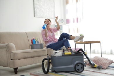 Photo of Happy woman having fun while cleaning room