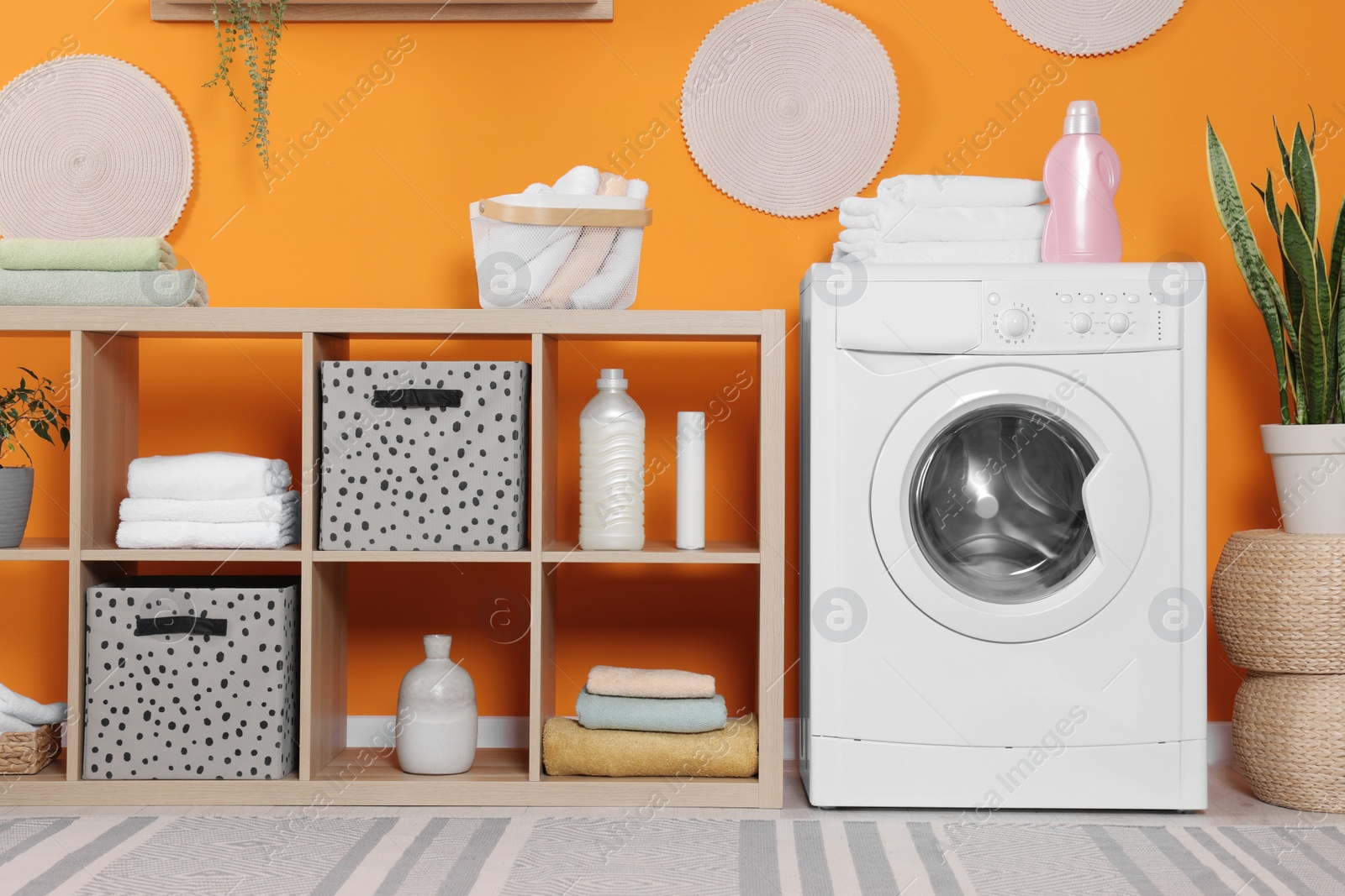 Photo of Stylish laundry room with washing machine. Interior design