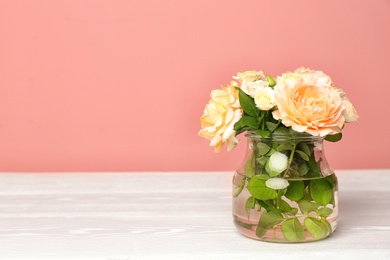 Vase with blooming flowers on table indoors