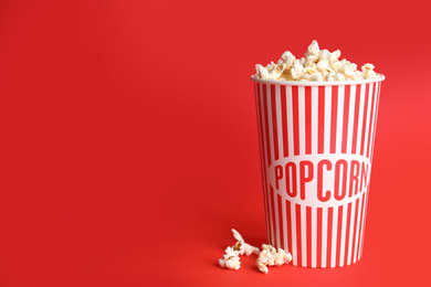 Photo of Tasty pop corn on red background. Space for text