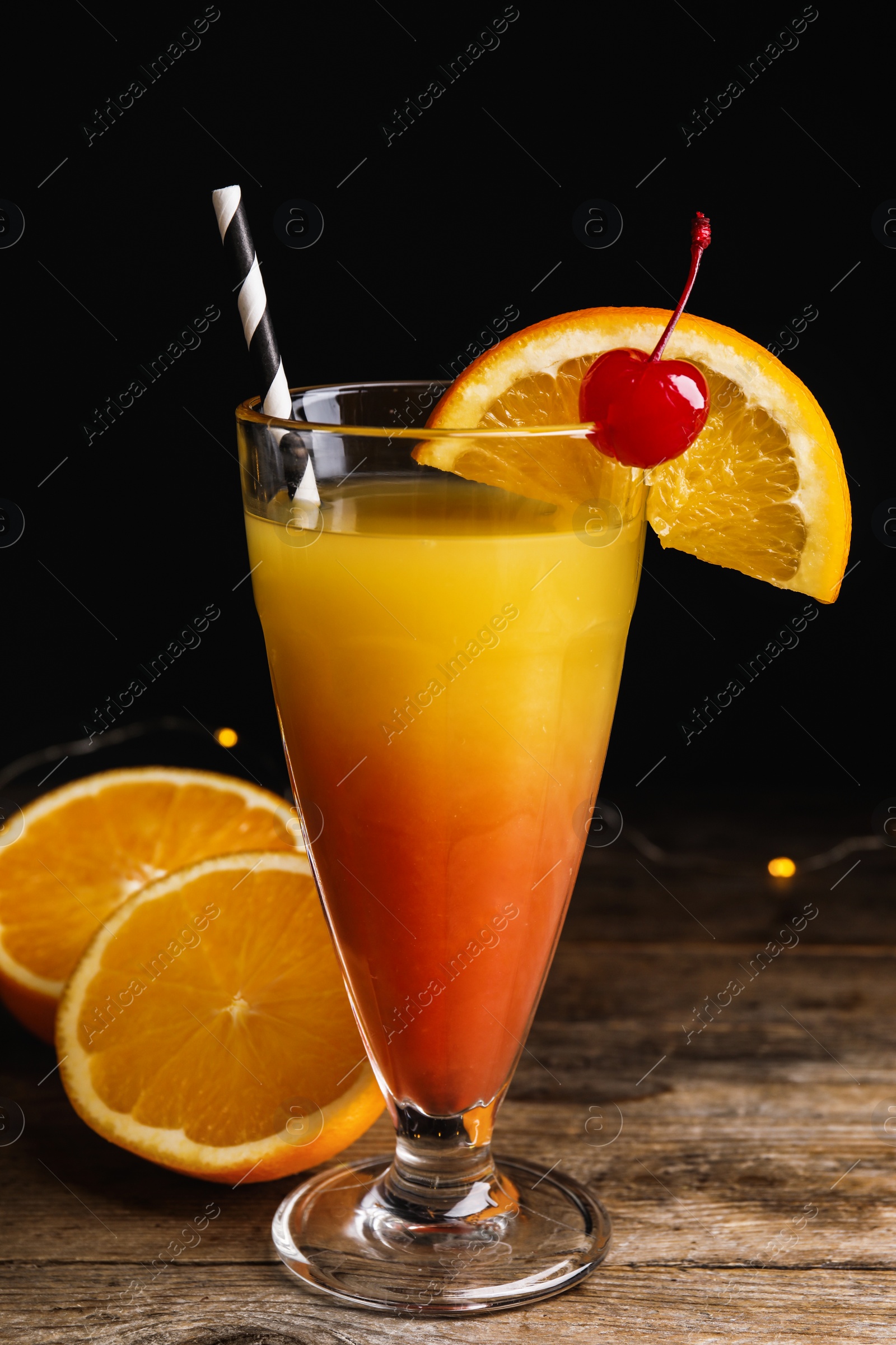 Photo of Fresh alcoholic Tequila Sunrise cocktail on wooden table