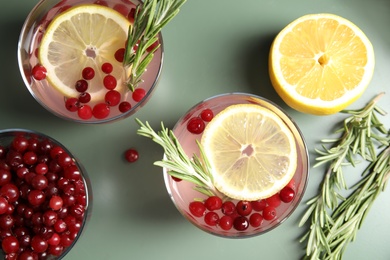 Flat lay composition with cranberry and rosemary cocktail on color table