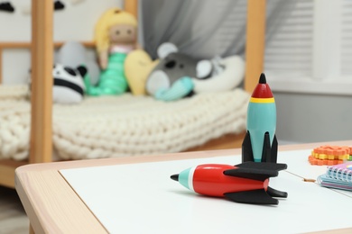 Photo of Table with toy rockets and notebooks in playroom
