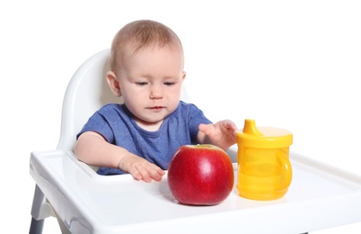 Photo of Adorable little child having breakfast in highchair against white background. Healthy baby food