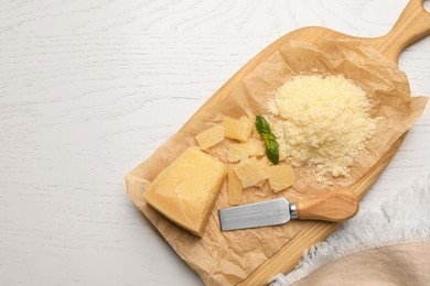 Photo of Delicious parmesan cheese on white wooden table, flat lay. Space for text