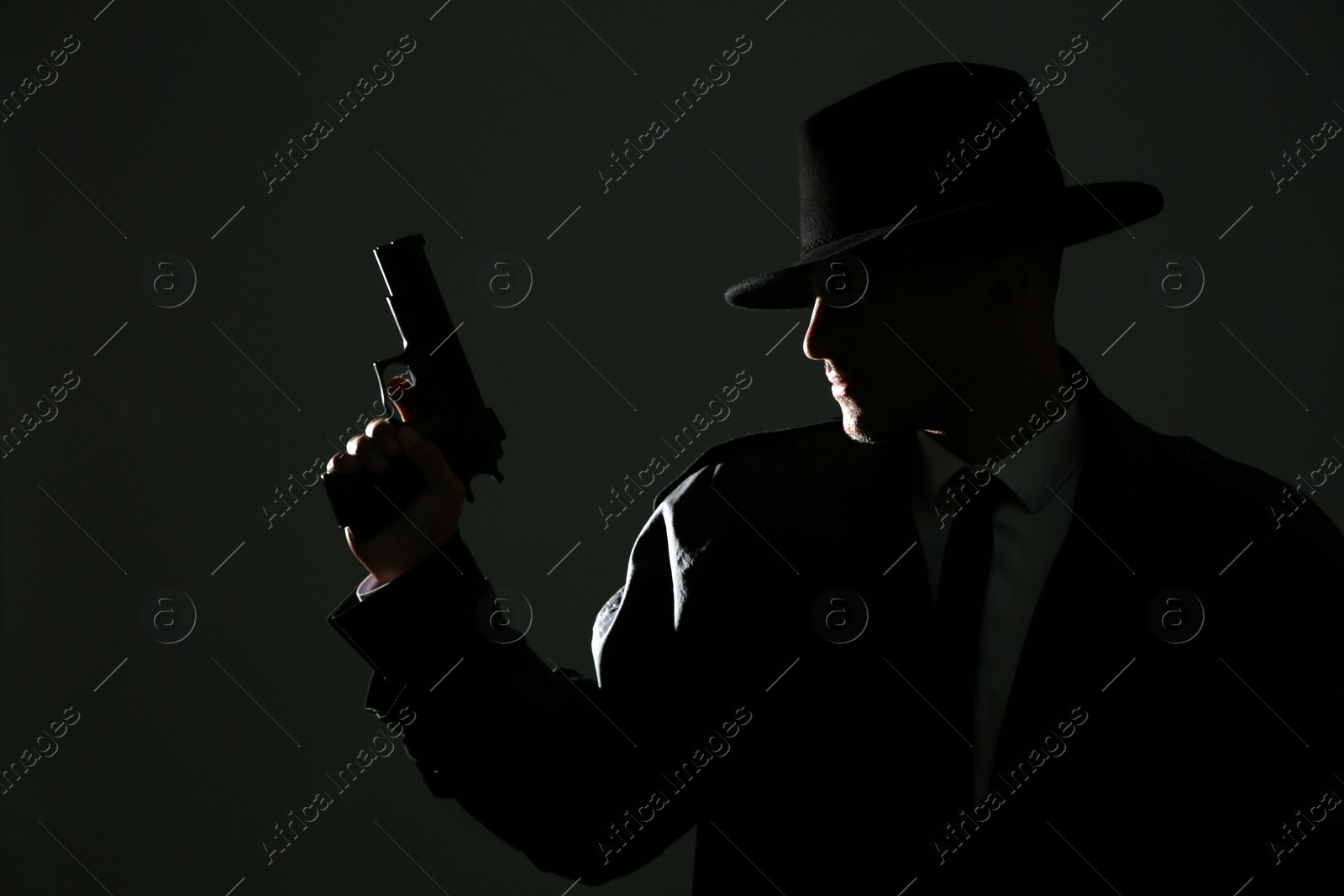 Photo of Old fashioned detective with gun on dark background