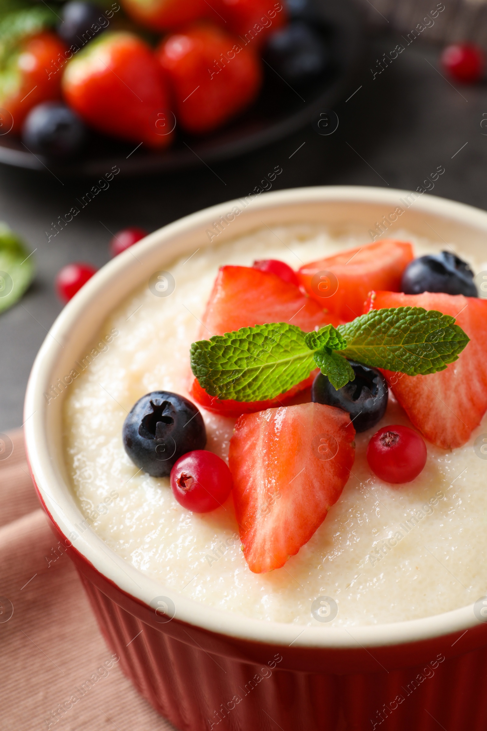 Photo of Delicious semolina pudding with berries and mint, closeup