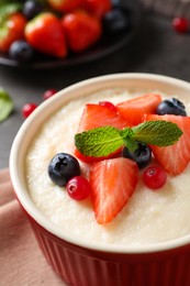 Photo of Delicious semolina pudding with berries and mint, closeup