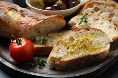 Photo of Tasty bruschettas with oil and thyme on plate, closeup