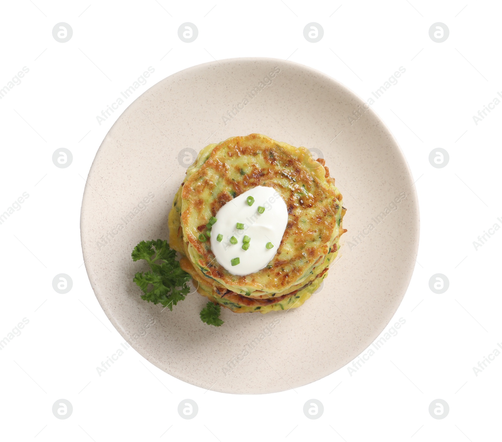 Photo of Delicious zucchini fritters with sour cream isolated on white, top view