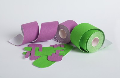 Photo of Bright kinesio tape rolls and pieces on light background