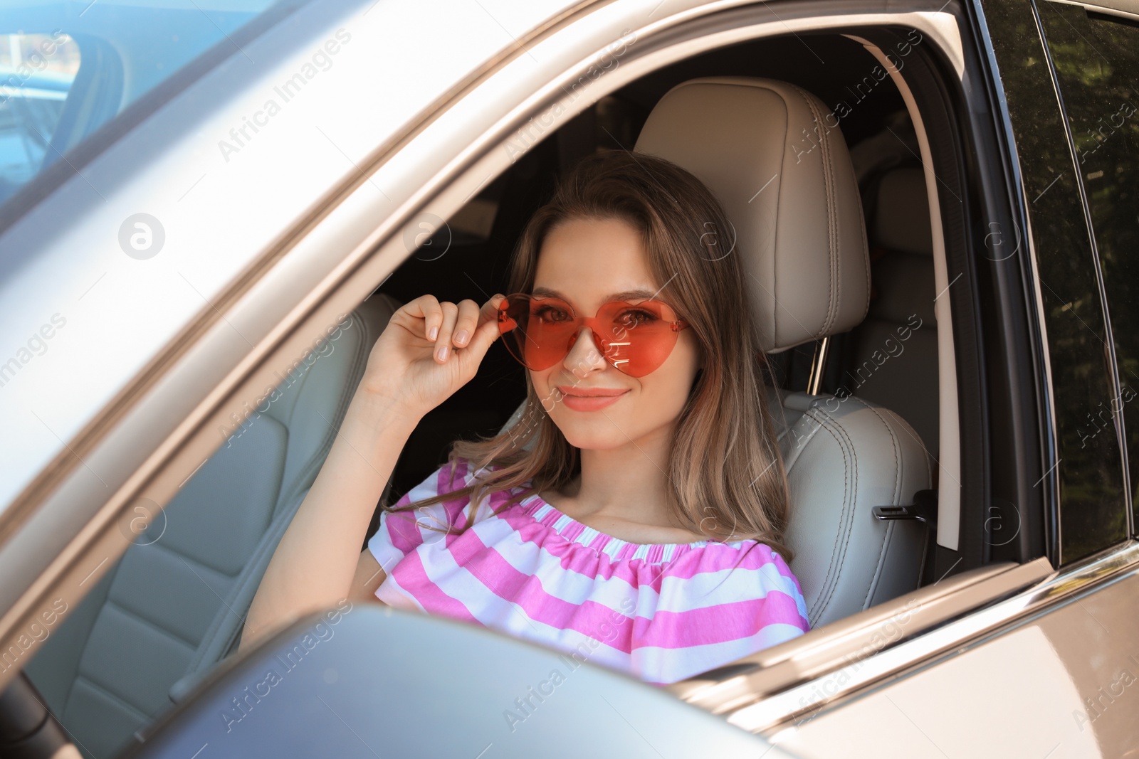 Photo of Happy woman with heart shaped glasses in car