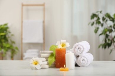 Photo of Composition with different spa products and plumeria flowers on white marble table indoors, space for text