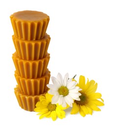 Photo of Stack of natural beeswax cake blocks and flowers on white background
