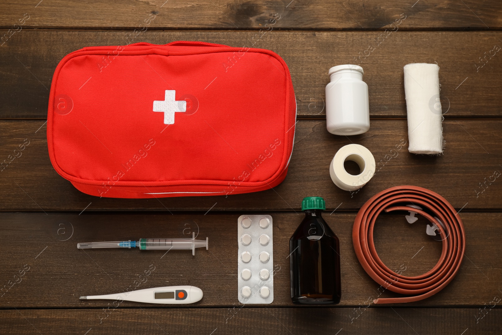 Photo of First aid kit on wooden table, flat lay