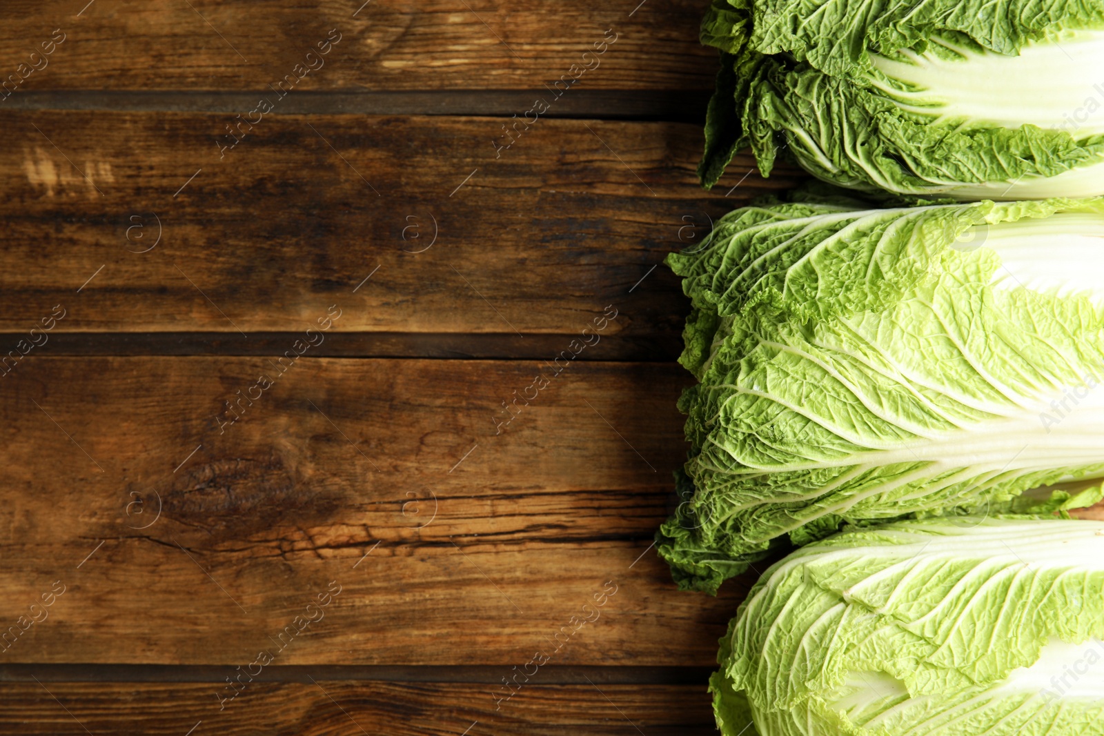 Photo of Fresh ripe Chinese cabbages on wooden table, flat lay. Space for text