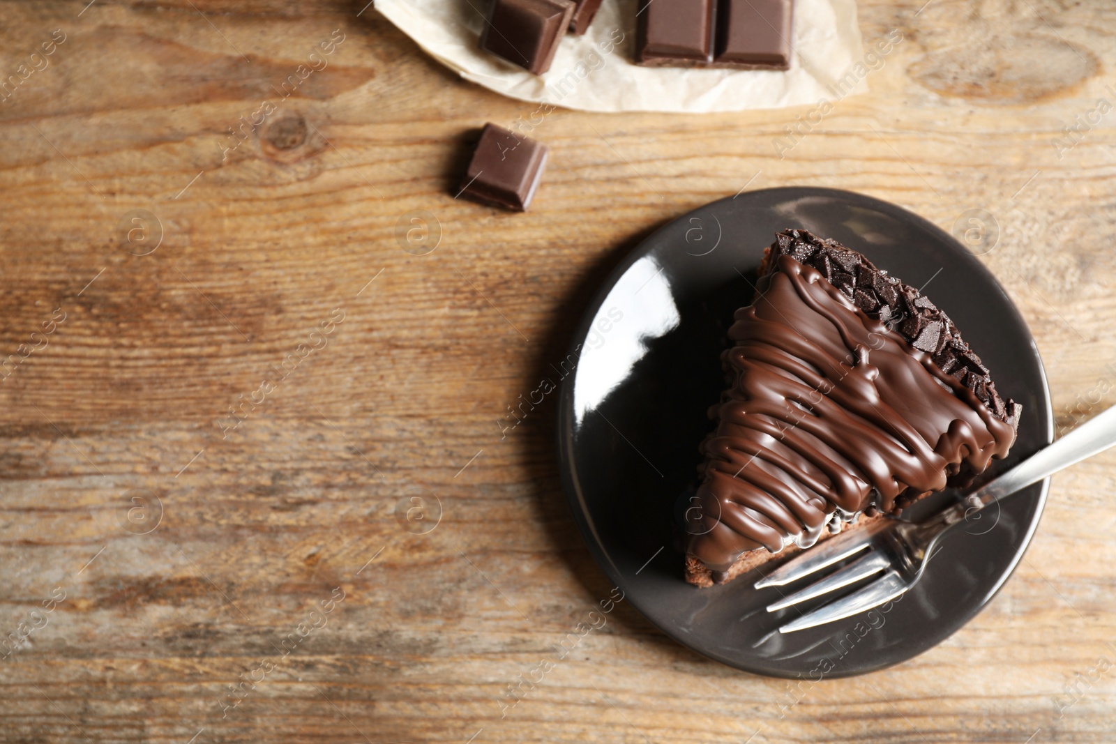 Photo of Tasty chocolate cake served on wooden table, top view. Space for text