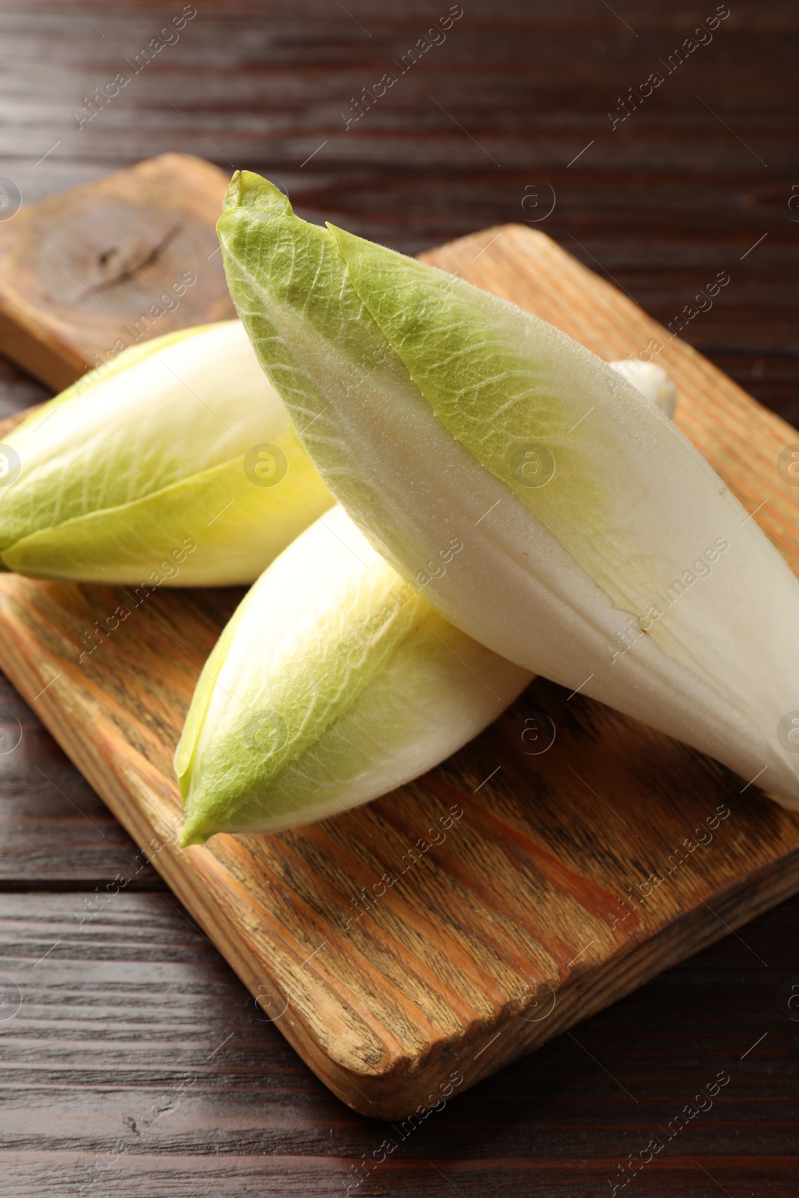 Photo of Raw ripe chicories on wooden table, closeup